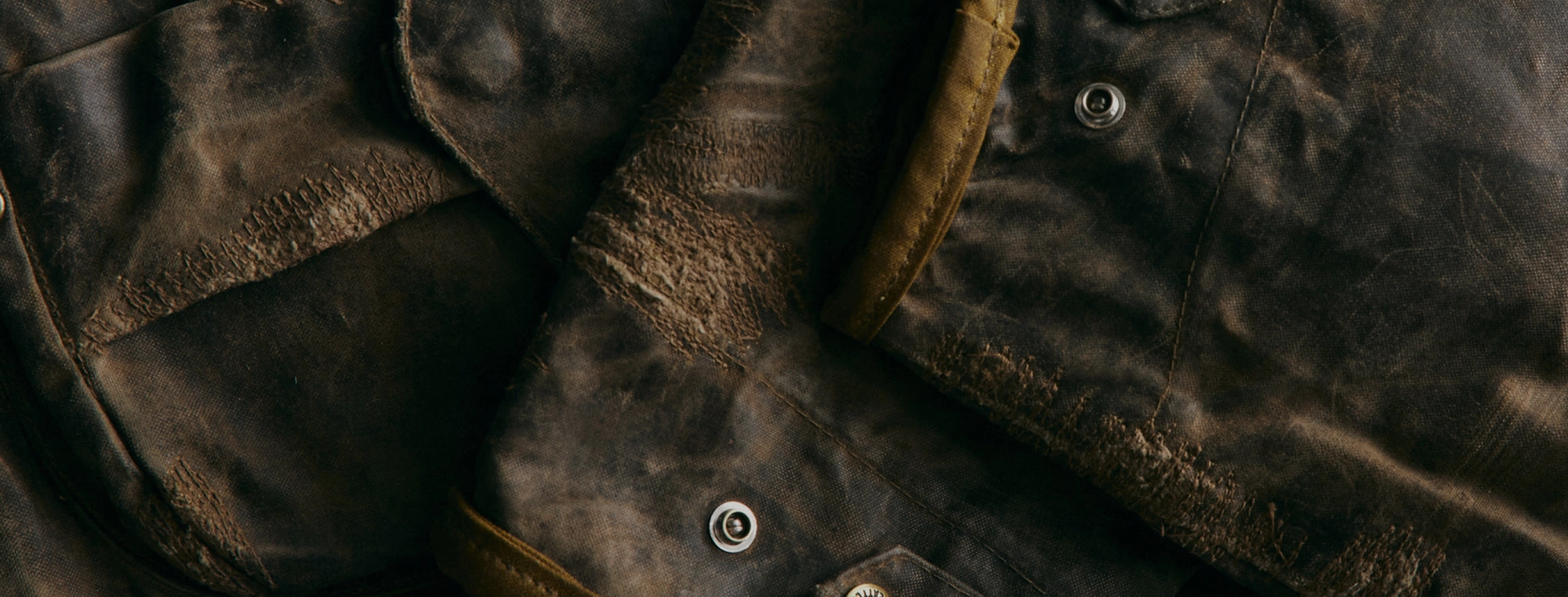 Close-up of dark waxed leather with a metal snap