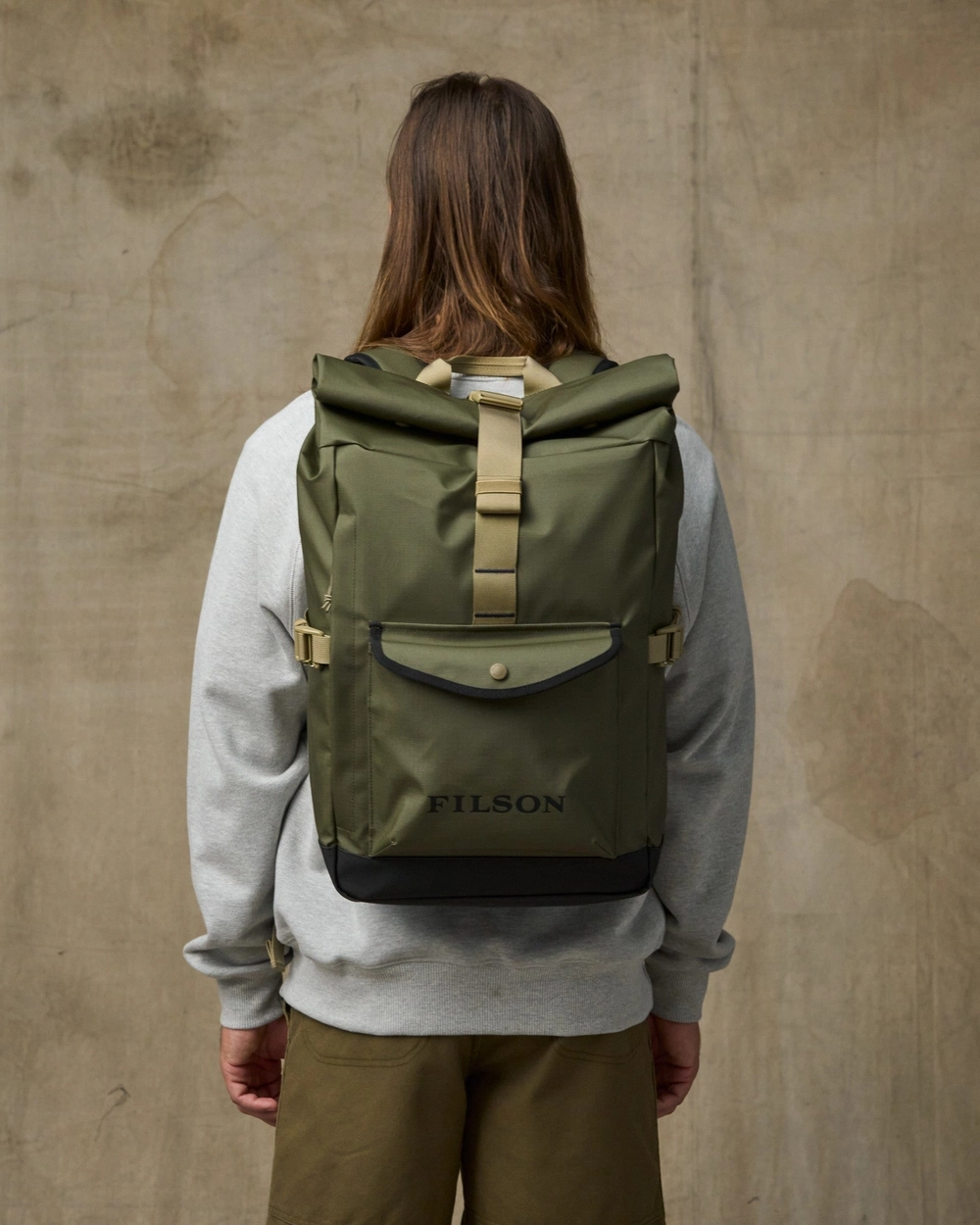 Person seen from behind wearing an olive backpack