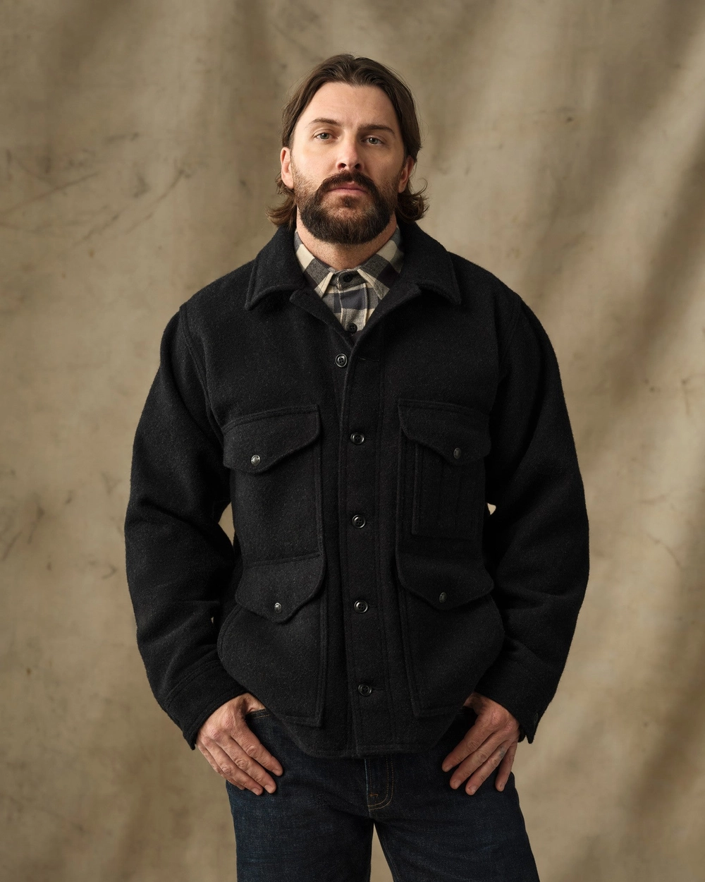 Man in a black Mackinaw wool jacket with his hands in the pockets